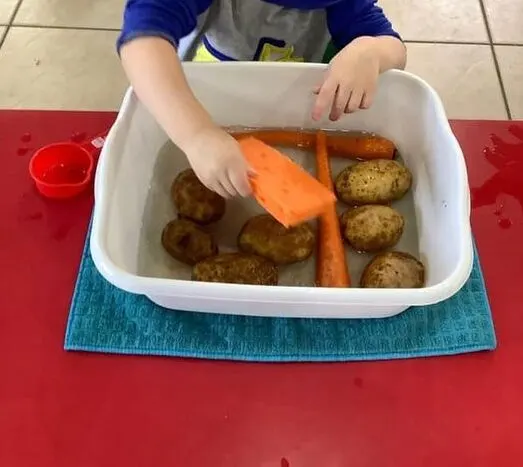 thanksgiving toddler activity washing the potatoes for thanksgiving dinner