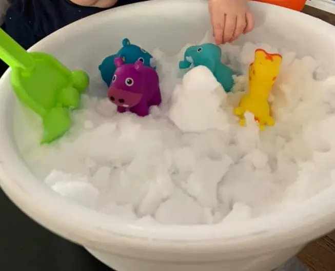 snow sensory bin in a tub with toys 