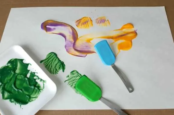 toddler painting using spatulas process art