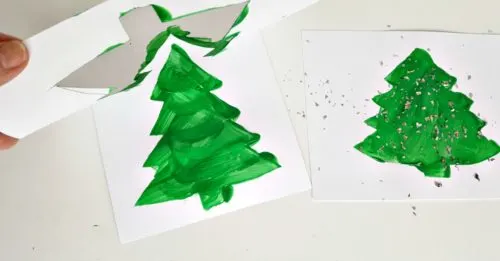 lifting Christmas tree stencils to reveal finished painting