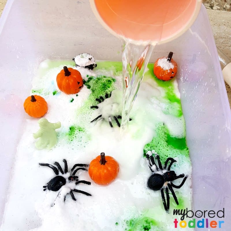 Halloween fizzy sensory bin with spiders and pumpkins vinegar and baking soda