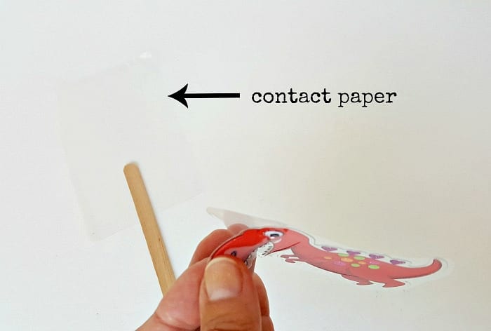 Remove sticker from adhesive backing to make craft stick puppet