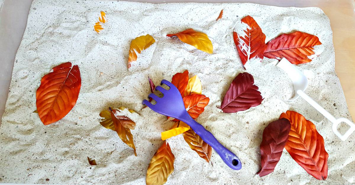 Raking leaves toddler activity in the sandbox