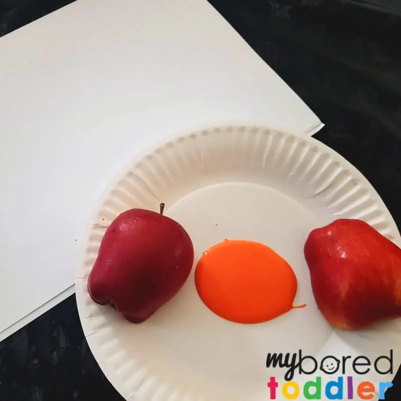 apple printing pumpkin Halloween craft for toddlers setting up the paint