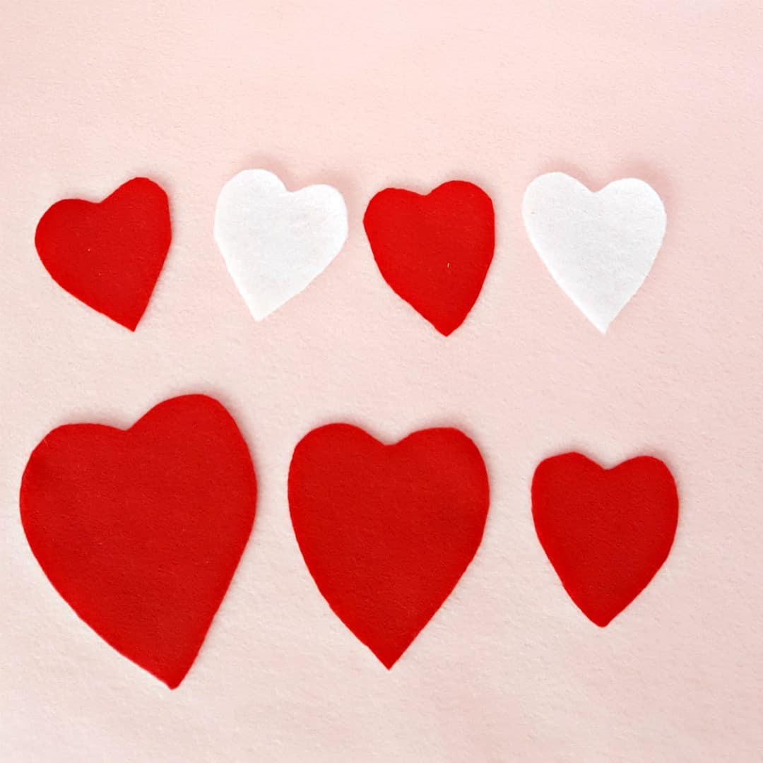 Arrange hearts in patterns toddler Valentine's day heart felt board activity 