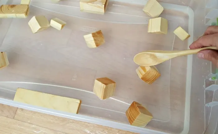 Stir small blocks in water play activity