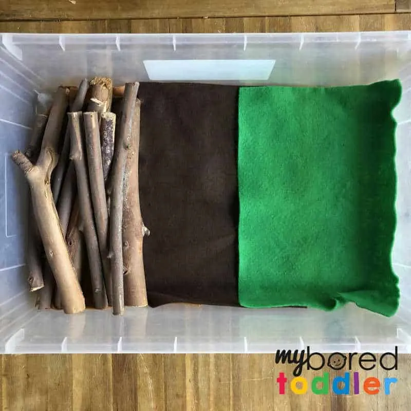setting up a sensory wood pile small world play for toddlers 2
