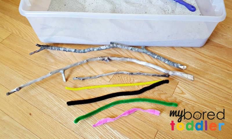 Sand in the sensory bin with pipe cleaner caterpillars and small twigs1