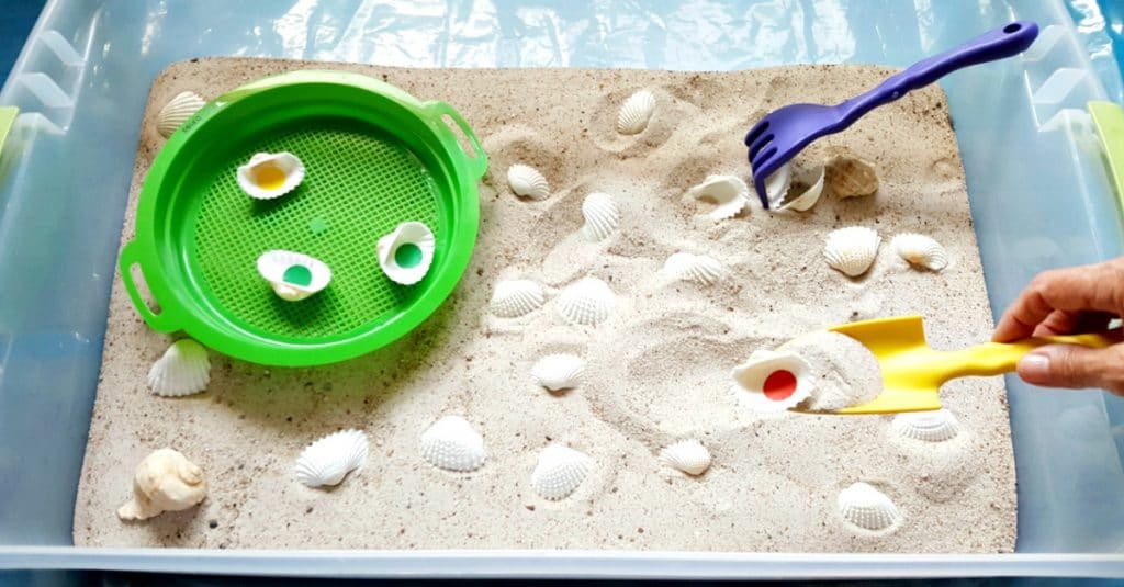 Digging for seashells in the sensory bin - My Bored Toddler