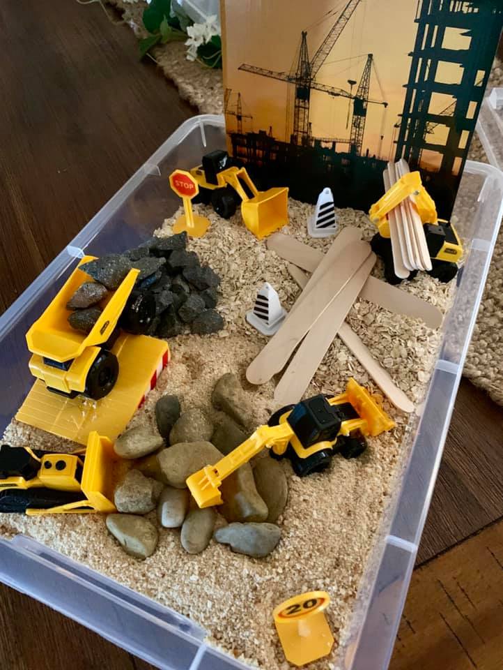 construction digger themed sensory bin for toddlers and preschool using oats and bread crumbs. 