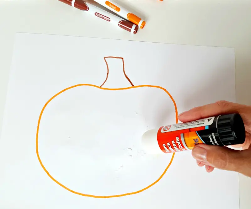 Spread glue onto the pumpkin picture with a glue stick
