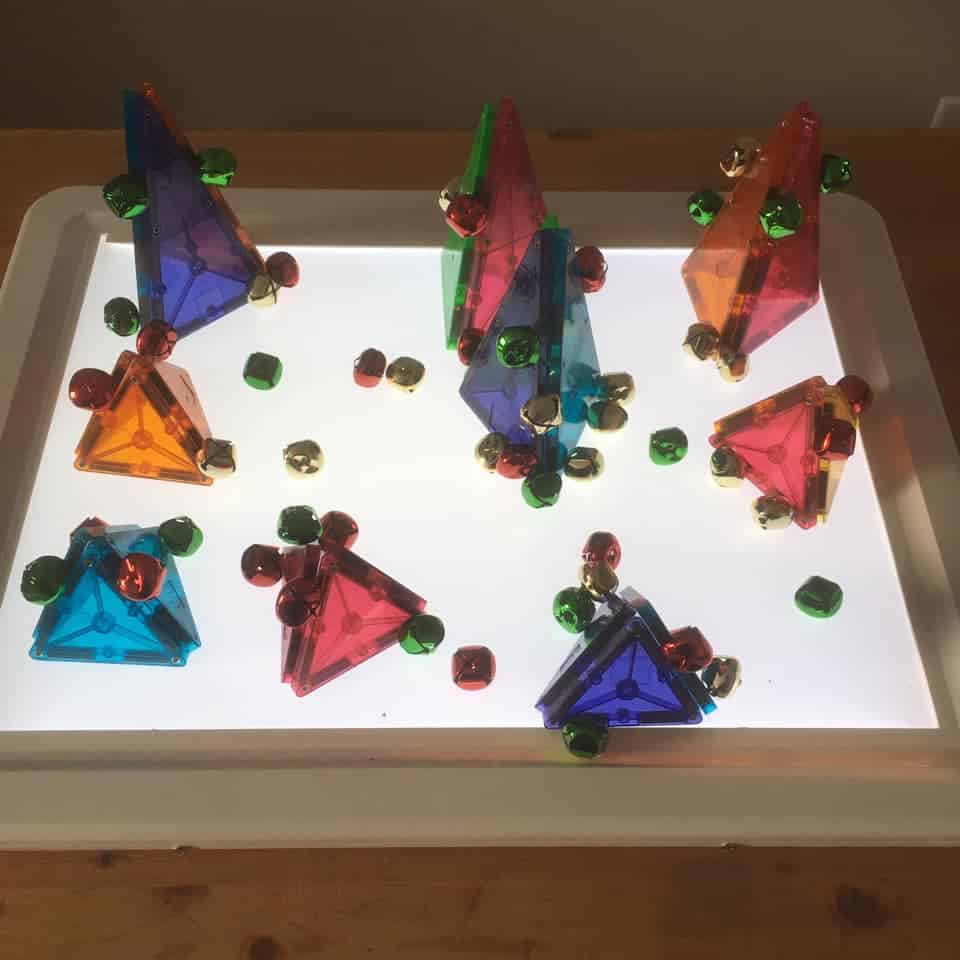 magnatiles and jingle bells on the light table