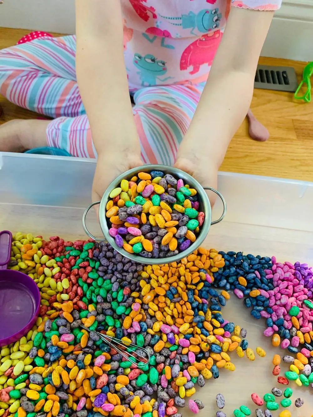 playing with magic beans dyed and colored for a sensory bin