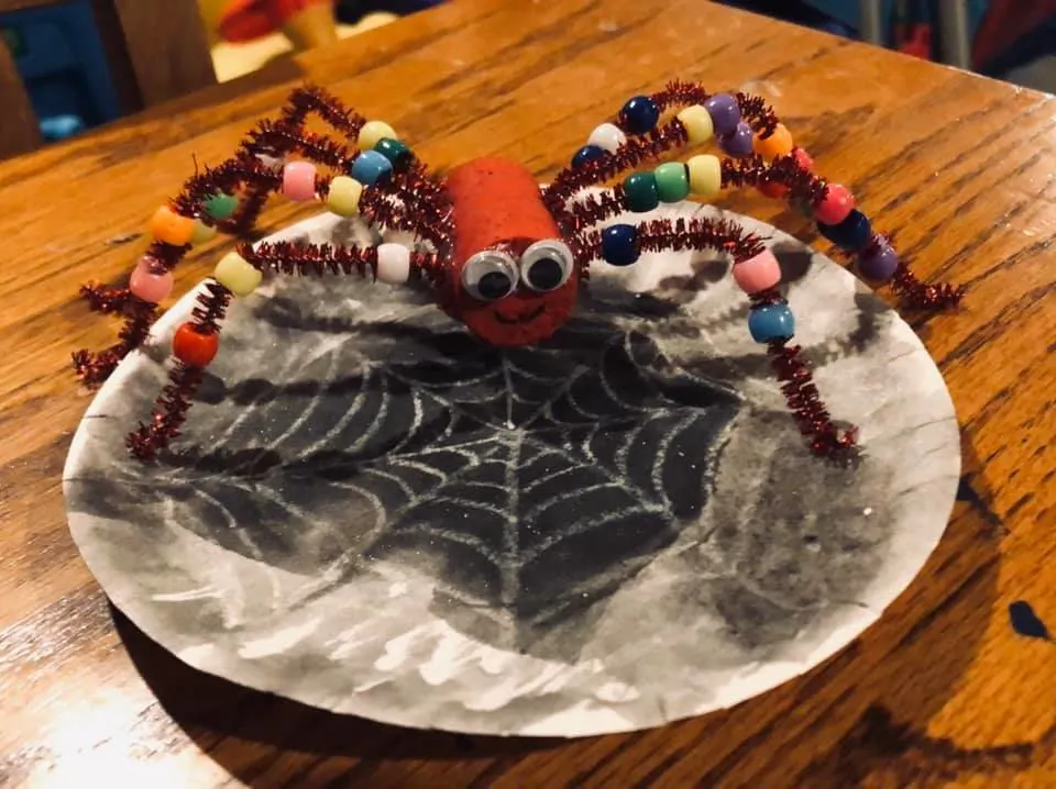 spider craft threading beads onto a the pipe cleaner.