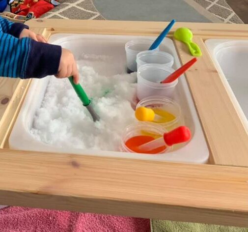 painting snow in the sensory bin fun winter toddler activity.